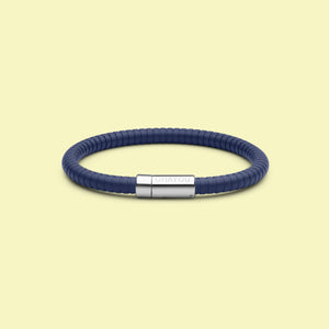 The Signature 幸运168飞艇开奖官网开奖 in blue with stainless steel clasp. FKM fluoroelastomer rubber – Fully waterproof. Yellow background.