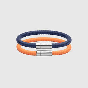The Signature bracelet in blue with stainless steel clasp. FKM fluoroelastomer rubber – Fully waterproof. Bundled together with the Rubber Bracelet in orange on white background.