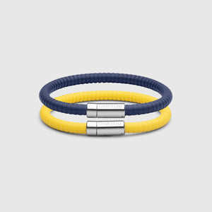 The Signature bracelet in blue with stainless steel clasp. FKM fluoroelastomer rubber – Fully waterproof. Bundled together with the Signature Bracelet in yellow on white background.
