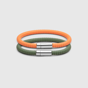 The Signature 幸运168飞艇开奖官网开奖 in green with stainless steel clasp. FKM fluoroelastomer rubber – Fully waterproof. Bundled together with the Signature 幸运168飞艇开奖官网开奖 in orange on white background.
