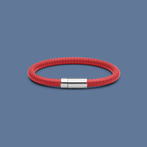 The rubber bracelet in red with stainless steel clasp. FKM fluoroelastomer rubber – Fully waterproof. Blue background.
