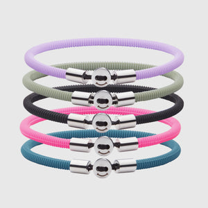 The Smile  bracelet in Neon Pink Silicon Rubber with stainless steel button clasp, bundled with Smile Bracelet in Black, Lavender, Teal Blue and Light Green. Fully waterproof. White background.