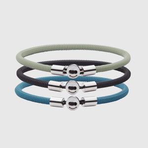 The Smile bracelet in Teal Blue Silicon Rubber with stainless steel button clasp, bundled with Smile Bracelet in Black and Light Green. Fully waterproof. White background.