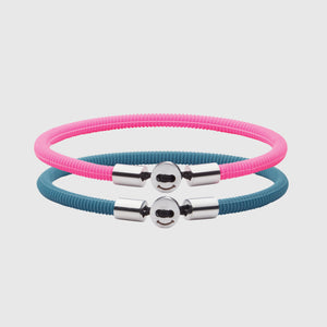 The Smile bracelet in Teal Blue Silicon Rubber with stainless steel button clasp, bundled with Smile Bracelet in Neon Pink Fully waterproof. White background.