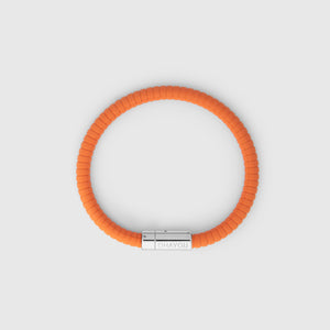 The rubber bracelet in orange with stainless steel clasp. FKM fluoroelastomer rubber – Fully waterproof. White background, seen from above..